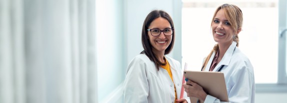 zwei Ärztinnen mit Tablet lächeln
