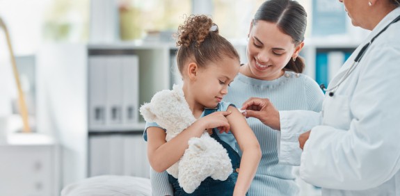 kleines Mädchen mit Mutter beim Impfen